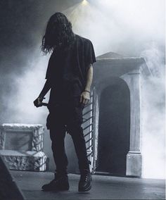 a man with long hair standing on stage