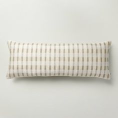 a white and brown checkered pillow sitting on top of a wall