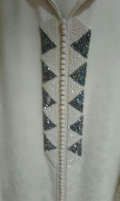 a white jacket with blue and silver sequins on it