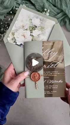 a person holding an envelope with flowers on it and a card in front of them