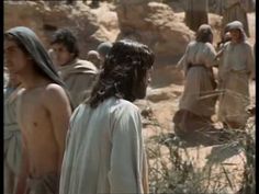 some people are standing in the desert with no shirt on and one is wearing a white robe