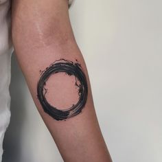 a black circle tattoo on the arm