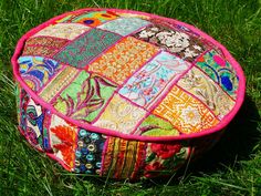 a colorful patchwork ottoman sitting in the grass