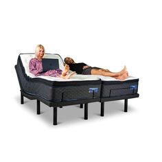 two people laying on top of an adjustable bed