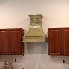 a kitchen with wooden cabinets and a gold range hood