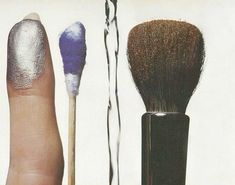 a hand holding a brush next to two other brushes