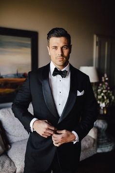 a man in a tuxedo poses for the camera