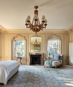 a bedroom with a bed, chandelier and fireplace in it's center