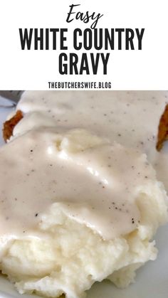 a white plate topped with mashed potatoes covered in gravy