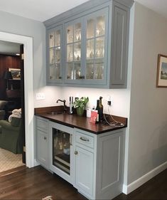 a kitchen with gray cabinets and wooden counter tops