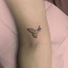 a small bird tattoo on the left side of the right arm is shown in black ink