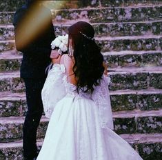 a bride and groom walking up some steps