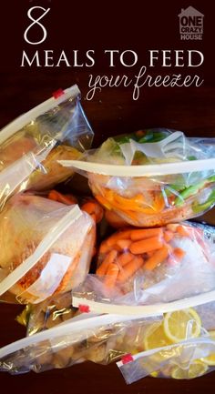 bags filled with food sitting on top of a wooden table next to lemons and carrots