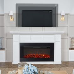 a living room with a fireplace and television on the wall, decorated with christmas ornaments