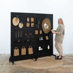 a woman standing next to a black display case