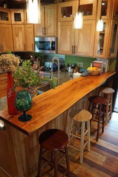 a kitchen with wooden cabinets and an island in the middle, surrounded by stools