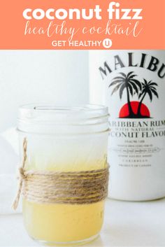 a glass jar filled with yellow liquid next to a bottle of malubu rum