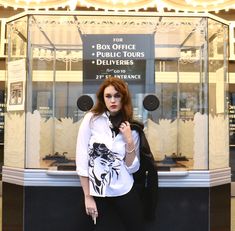 a woman standing in front of a glass display case