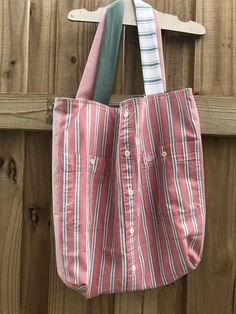 a red and white striped bag hanging on a wooden fence