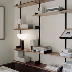 a book shelf with books on it and a lamp in the corner next to it