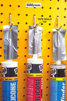 three different types of adhesives hanging on a yellow wall with pegs attached to them