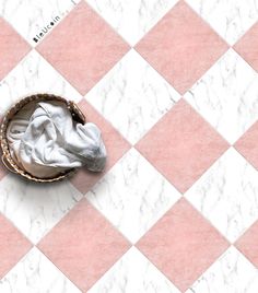 a white and pink checkered floor with a basket filled with laundry on top of it