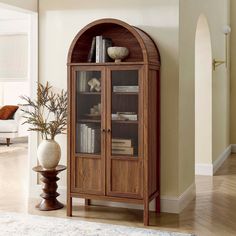 a tall wooden cabinet with glass doors in a living room