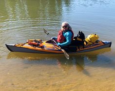 an older woman in a kayak with her dog