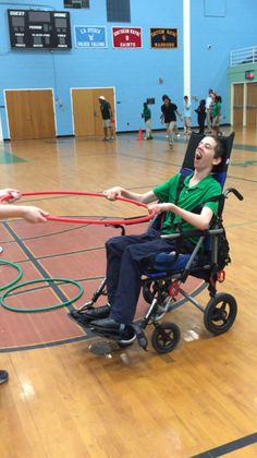 a man in a wheel chair holding onto another person's hand with a rope