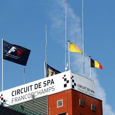 several flags flying on top of a building with a sign that says circuit de spa