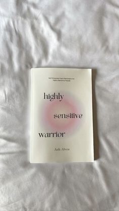 a book sitting on top of a bed covered in white sheets and pillows, with the title highly seductive warrior