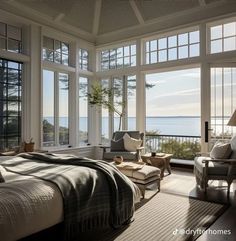 a bedroom with large windows overlooking the ocean