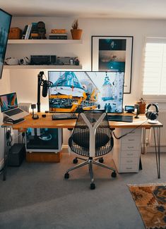 a desk with a computer monitor and laptop on it