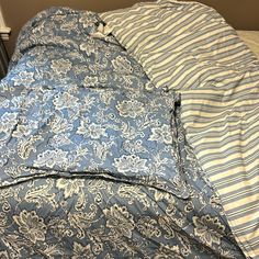 an unmade bed with blue and white sheets