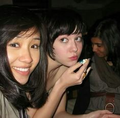 two young women are brushing their teeth with toothbrushes in front of the camera