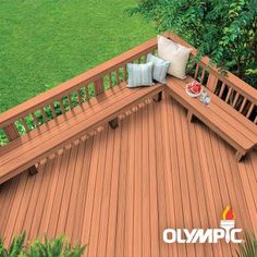 an aerial view of a wooden deck with pillows on it and trees in the background