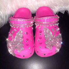 a pair of pink children's shoes with butterfly embellishments on them