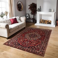 a living room filled with furniture and a rug on top of a hard wood floor