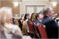 many people are sitting in chairs and listening to the speaker