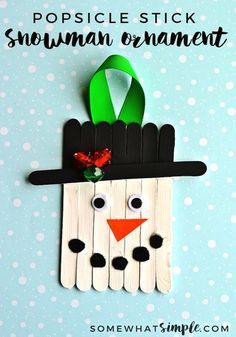 popsicle stick snowman ornament made with popsicle sticks and a green ribbon