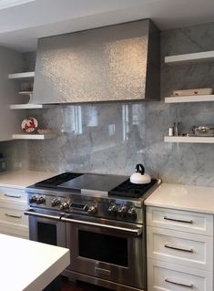 a stove top oven sitting inside of a kitchen next to white cupboards and shelves