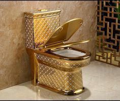 a gold toilet with its lid open and the seat up, sitting on a marble floor