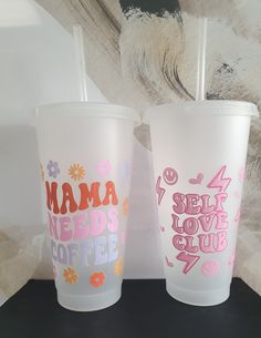 two plastic cups with the words mama needs coffee and self love club written on them