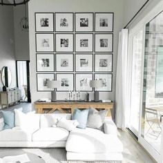 a living room filled with lots of furniture and pictures on the wall above it's windows