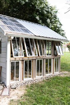 a small white house with lots of windows on top of it's roof and side walls