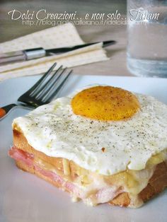 an egg and ham sandwich on a white plate