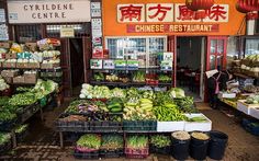 an outdoor market with lots of vegetables and fruits