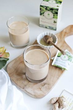 two glasses of coffee sitting on top of a wooden tray