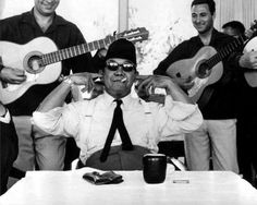 a group of men sitting around each other with guitars