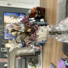 a vase filled with flowers sitting on top of a counter next to a microwave oven